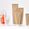 Paper-based material for body of easy to squeeze tube-shaped pouch further reduces plastic volume.