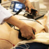 A white coat physician perform defibrillationon a doll during ACLS training program